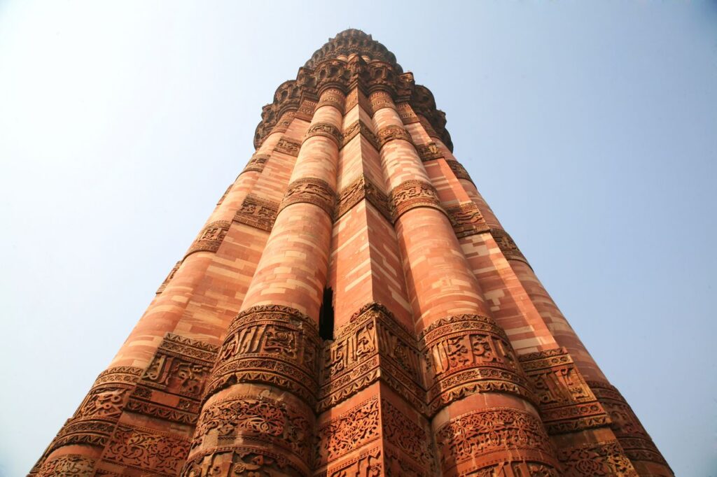 Majestic view of Qutub Minar against a clear blue sky in New Delhi, India.