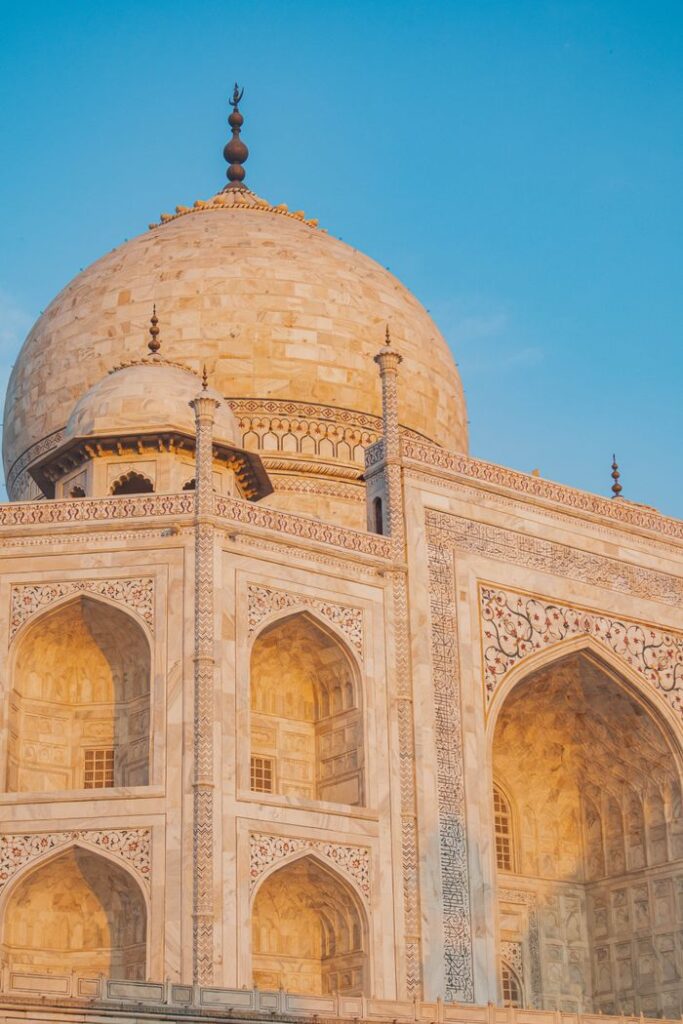 A stunning view of the Taj Mahal's intricate architecture under the golden sunset light in Agra, India.