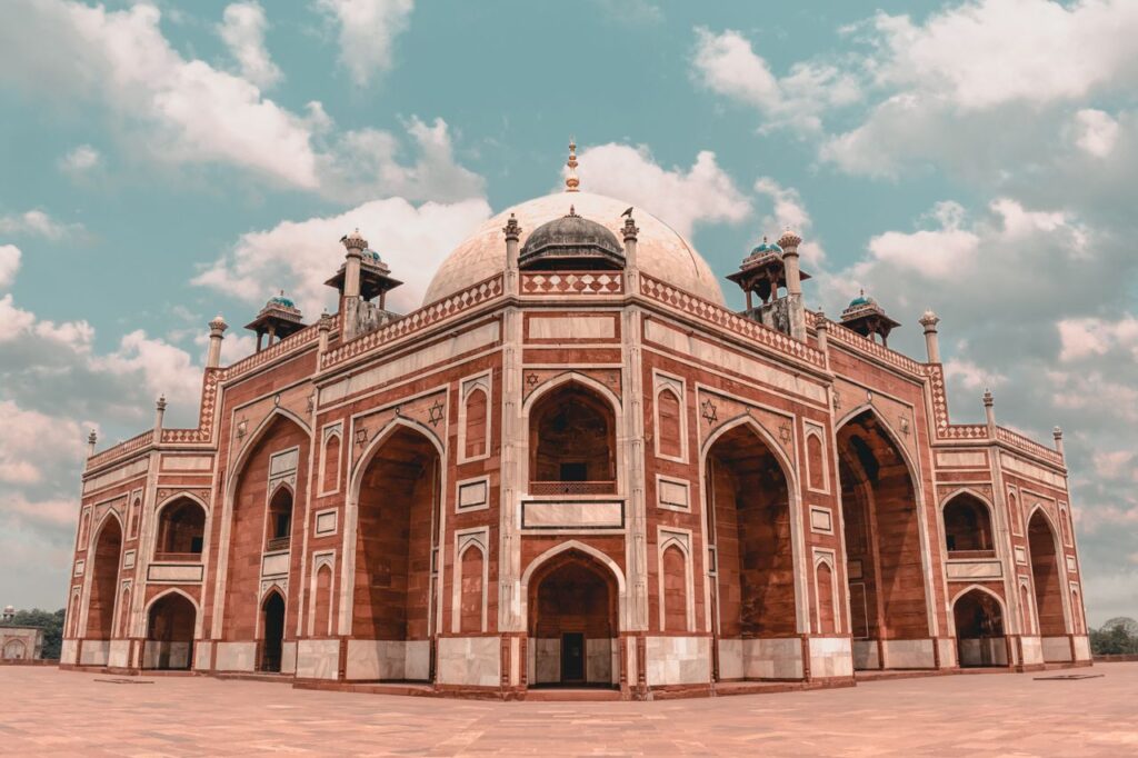 Stunning view of Humayun's Tomb in New Delhi, showcasing its intricate Mughal architecture under a bright, cloudy sky.
